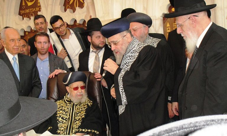 Coronation of Rabbi Yitzchak Yosef as Sephardi Chief Rabbi of Israel. Seen in picture: President Shimon Peres (far left), Rabbi Ovadia Yosef (seated), Rabbi Yitzchak Yosef (speaking into microphone), Rabbi Shalom Cohen (far right).